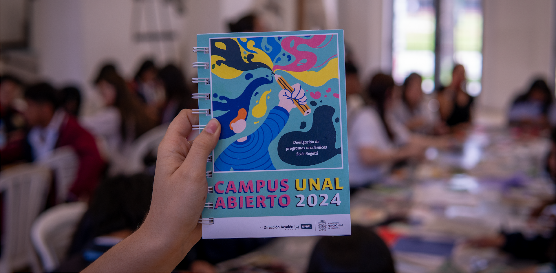Foto sosteniendo un cuaderno del campus abierto 2024
